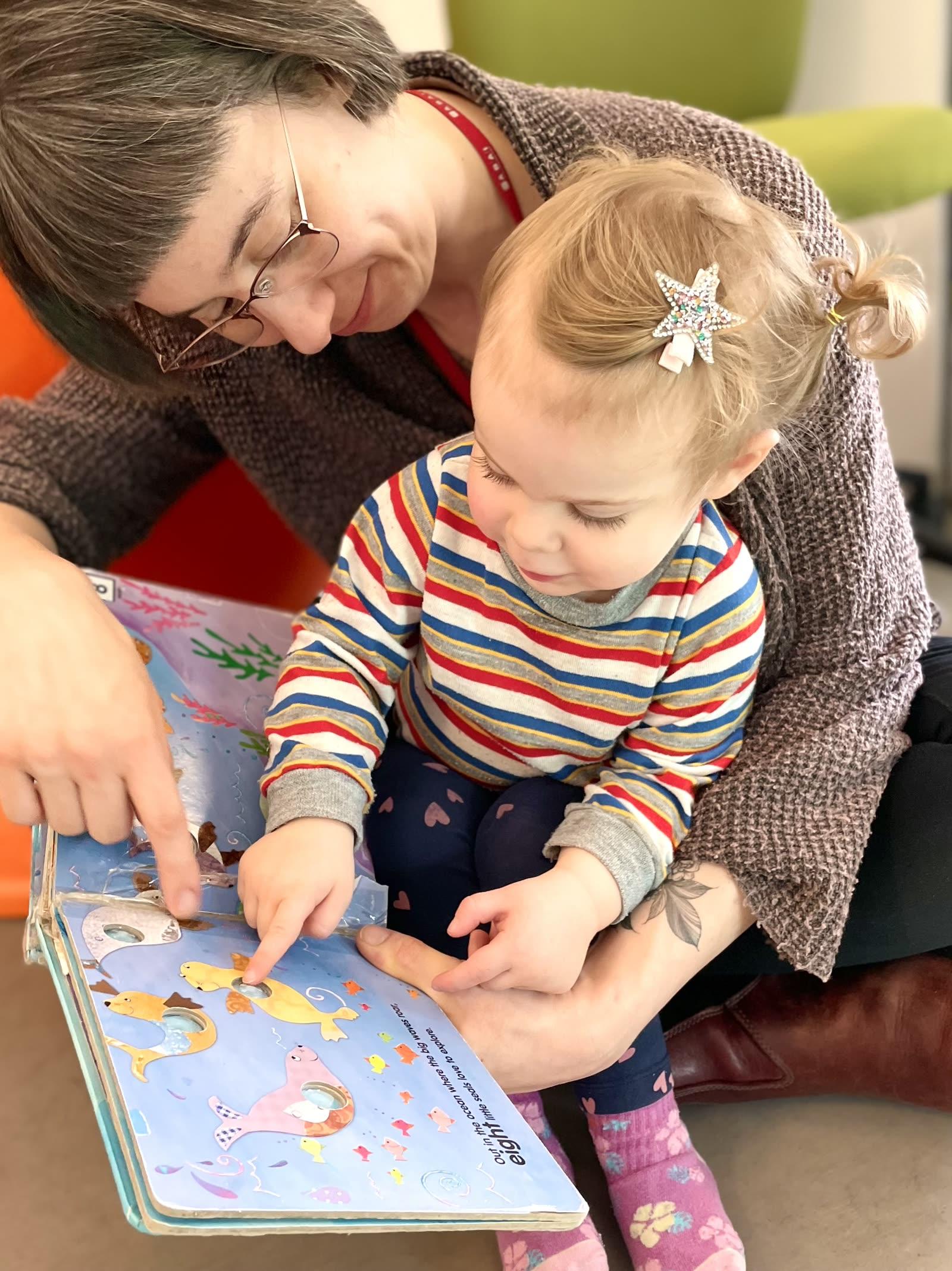 A UP Early clinician reading a picture book with a toddler, pointing out pictures together